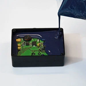Vacuum potting process with black epoxy resin being dispensed into automotive PCB assembly for complete component encapsulation and environmental protection