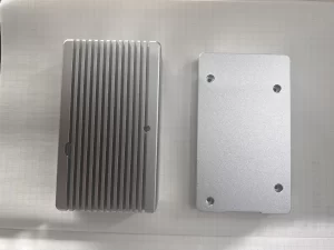 Top and bottom view details of AL6061 CNC-machined enclosure for Raspberry Pi CM4 industrial applications showing integrated cooling fins, mounting bosses, PCB alignment features, and I/O cutout positions